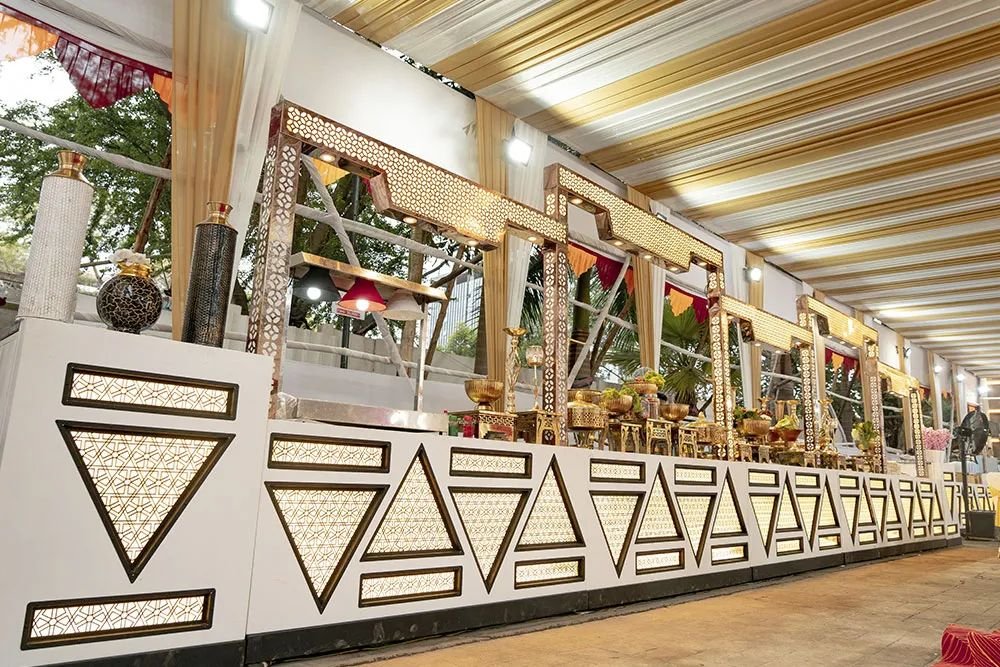 Decorated serving counters lined up under the lawn canopy